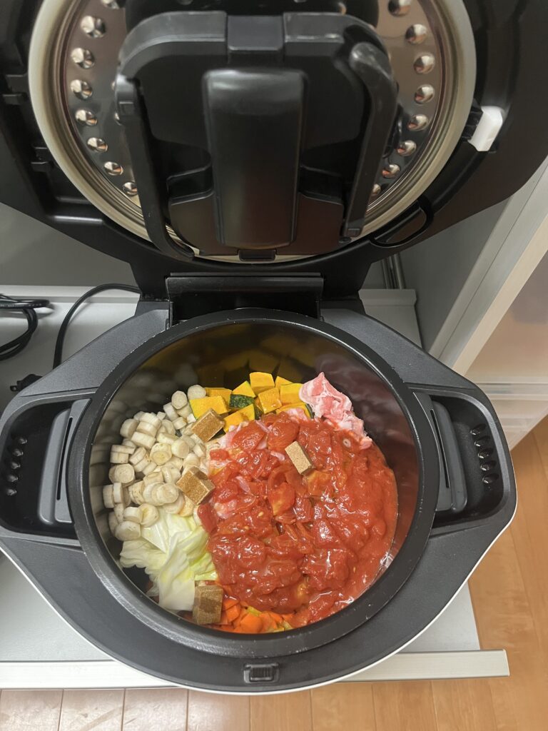 トマト缶とコンソメキューブをのせてホットクックにセットしたトマトスープ


